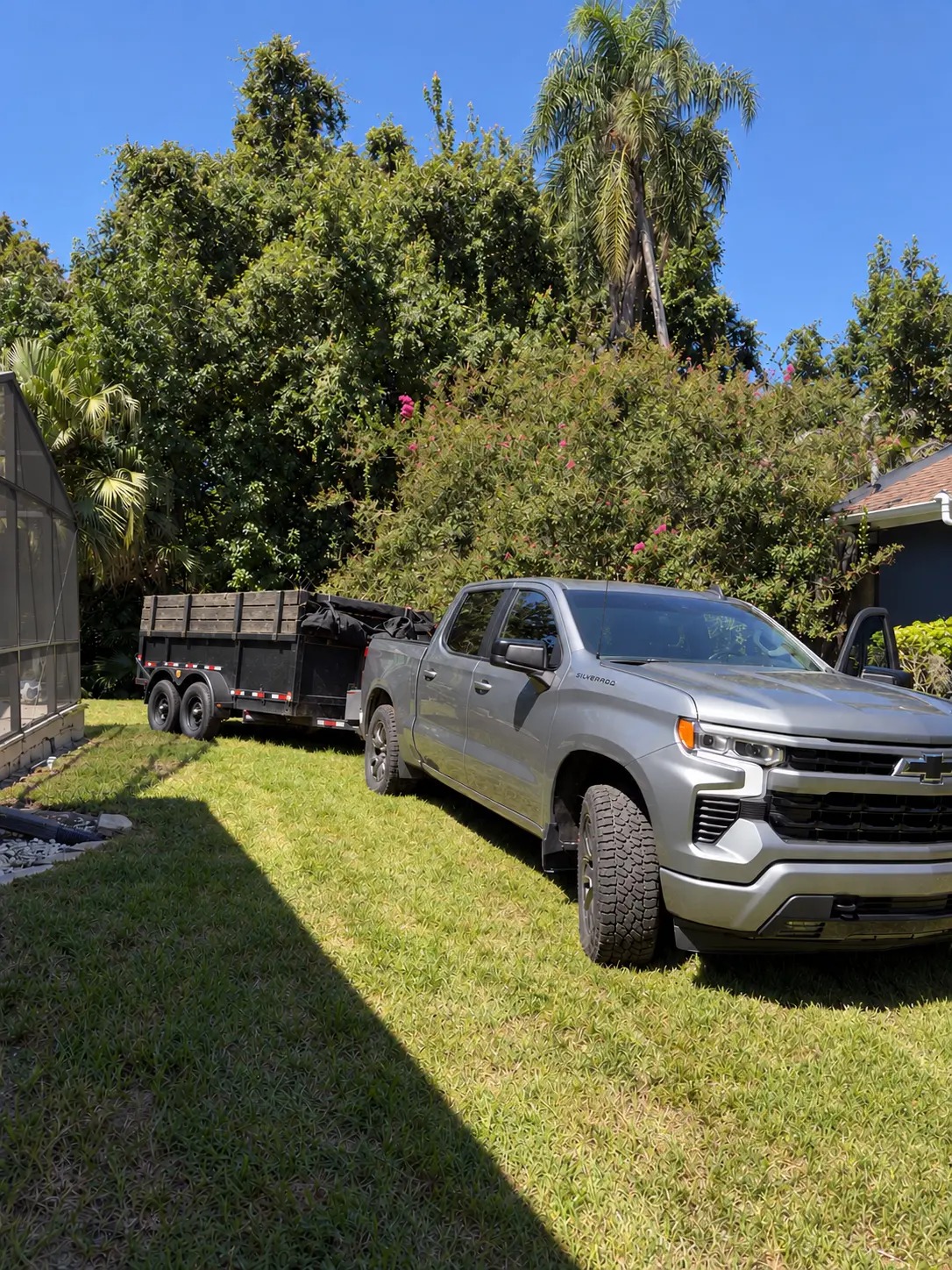 Colton's silver Chevy Silverado and black dump trailer in Palm Harbor